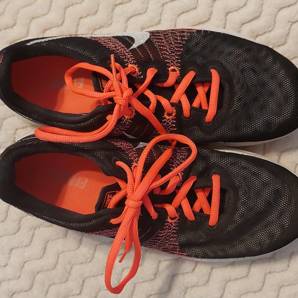 Previously loved Nike tennis shoes in size 9.5/41. Hot salmon with black mesh.